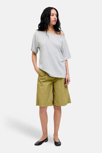 Groene korte broek van JJXX, lichte stof, zakken, model draagt grijze off-shoulder top en zwarte schoenen, front view
