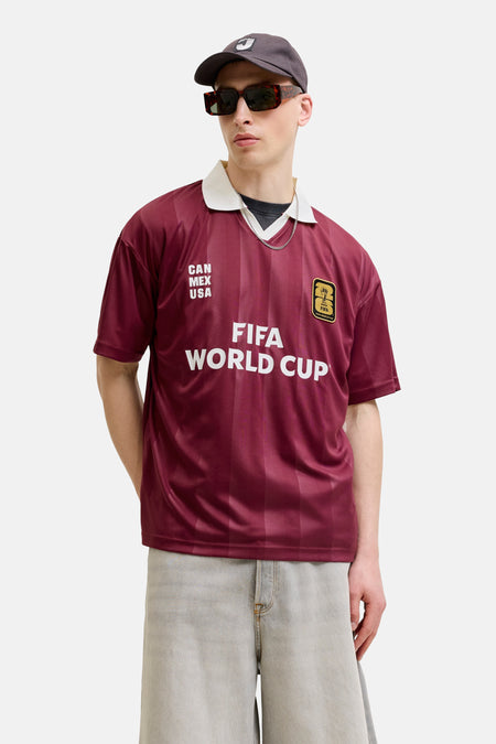 Bruine polo van ORIGINALS BY JACK & JONES met verticale strepen, witte kraag en FIFA World Cup-embleem.
