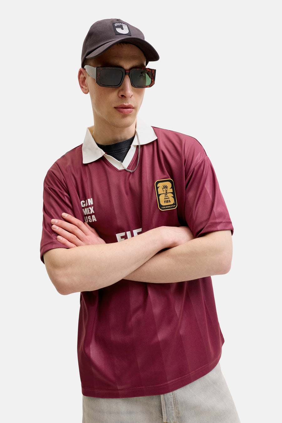 Bruin poloshirt van ORIGINALS BY JACK & JONES met witte kraag, subtiele verticale strepen en FIFA World Cup '26 patch.