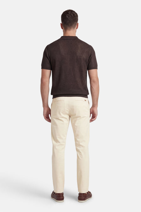 Ecru chino van JACK & JONES JEANS INTELLIGENCE, achterkant, gecombineerd met bruin poloshirt en bruine instappers.