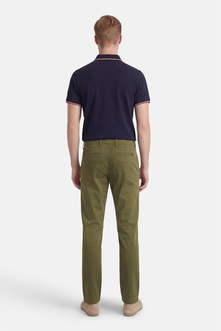 Groene chino van JACK & JONES JEANS INTELLIGENCE, gezien vanaf de achterkant, gecombineerd met een donkerblauw poloshirt en suède schoenen.