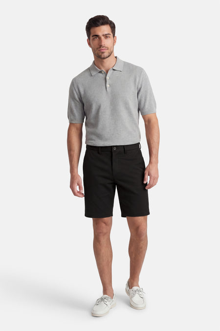 Zwarte short van JACK & JONES JEANS INTELLIGENCE, effen en gecombineerd met een grijs poloshirt en witte schoenen.