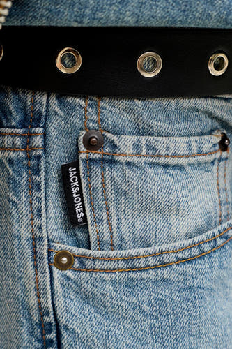 Jean droit en denim bleu clair de JACK & JONES, avec une étiquette noire et des surpiqûres marron sur la poche.