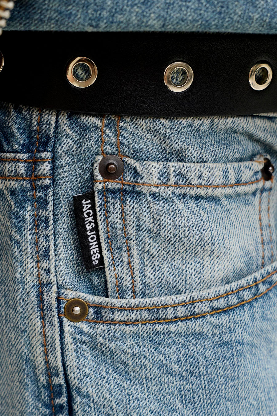 Jean droit en denim bleu clair de JACK & JONES, avec une étiquette noire et des surpiqûres marron sur la poche.