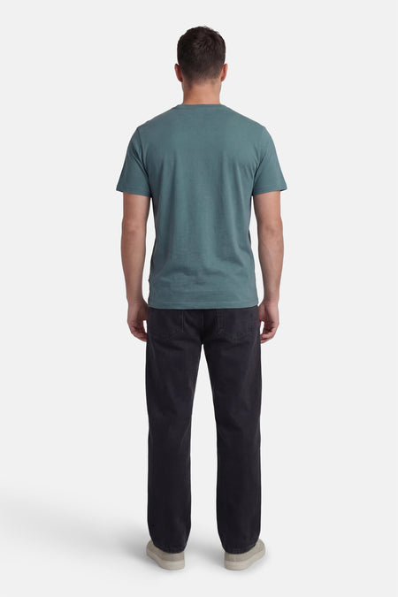 Groen T-shirt met korte mouwen van CORE BY JACK & JONES, gezien van achteren, gecombineerd met donkere jeans en lichte schoenen.