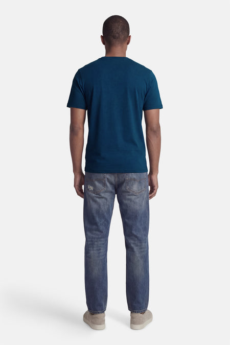 Blauw T-shirt met korte mouwen van CORE BY JACK & JONES, gezien van achteren, gecombineerd met een jeans en grijze schoenen.