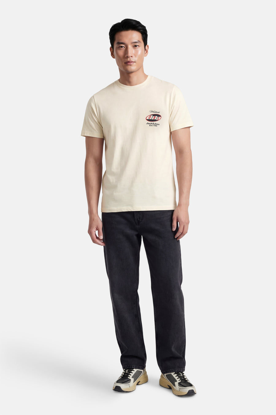 Ecru T-shirt met korte mouwen van ORIGINALS by JACK & JONES, met een logo op de borst, gecombineerd met een donkere jeans en sneakers.