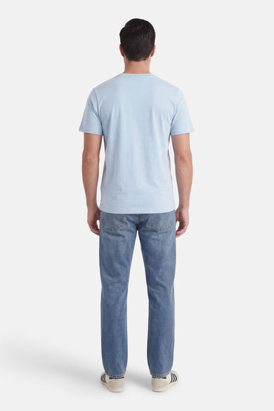 T-shirt bleu à manches courtes de ORIGINALS BY JACK & JONES, vu de dos, porté avec un jean et des baskets.