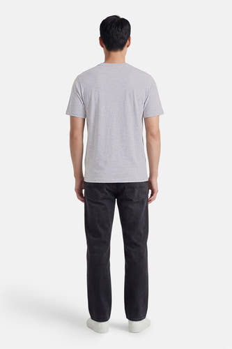 T-shirt gris de CORE BY JACK & JONES, vue arrière d'un homme avec un jean foncé et des baskets blanches.