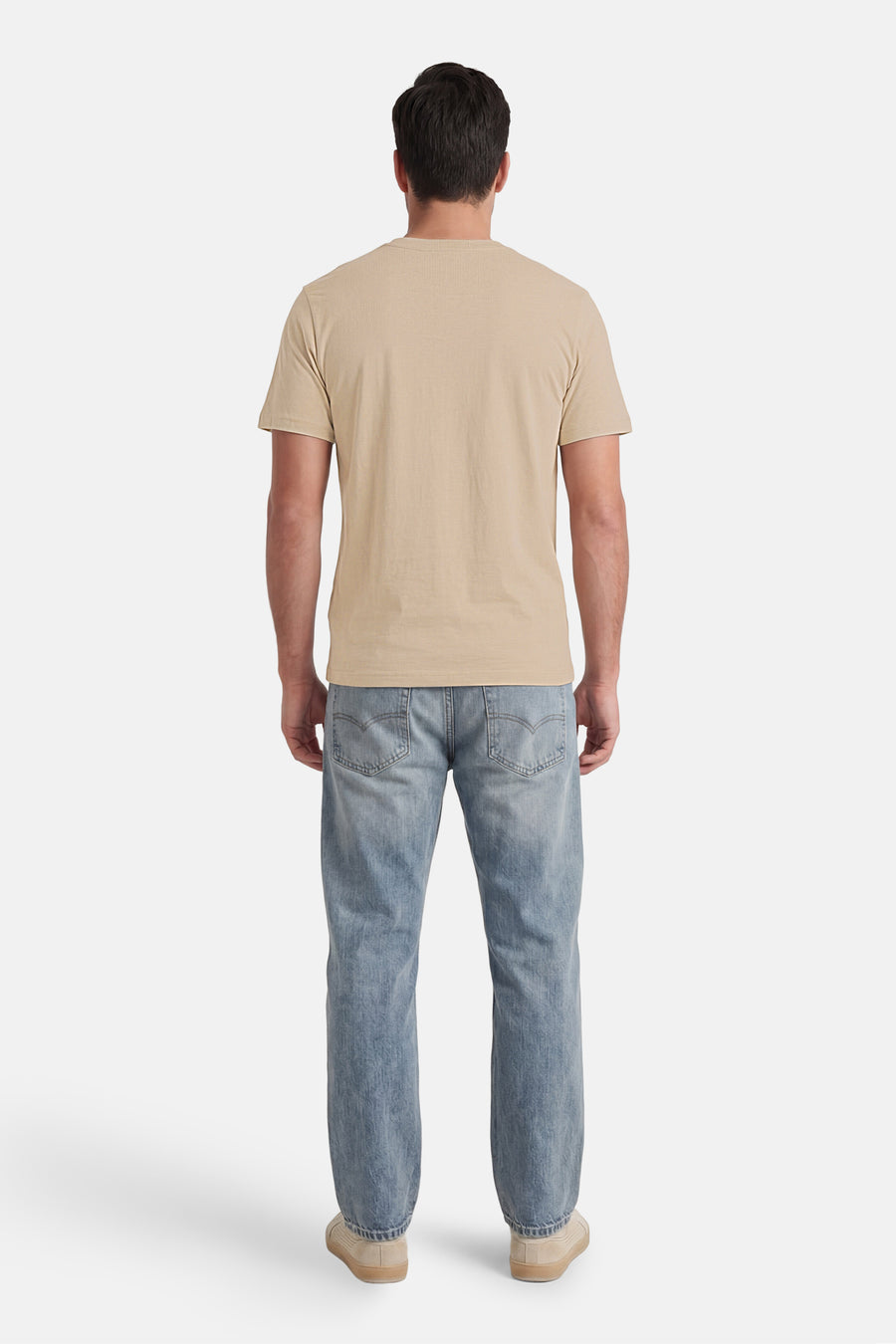 T-shirt beige à manches courtes de CORE BY JACK & JONES, vu de dos, porté par un homme avec un jean et des baskets.