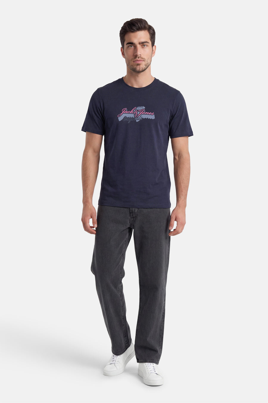 Donkerblauw T-shirt van ORIGINALS BY JACK & JONES met roze/blauwgrijze 'Jack & Jones Originals' print, gedragen met gestreepte jeans en witte sneakers.
