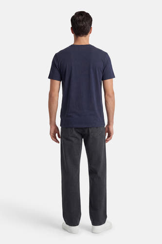 Donkerblauw T-shirt van ORIGINALS BY JACK & JONES, aan de achterkant gedragen door een man met een geribbelde donkergrijze broek en witte sneakers.
