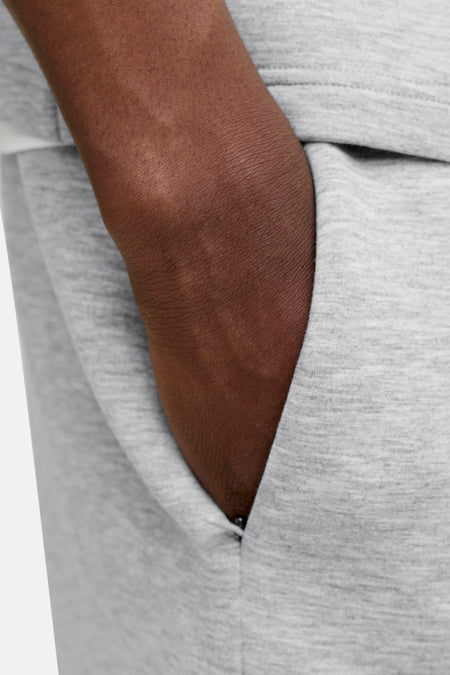 Grijze heren korte joggingbroek van JACK & JONES JEANS INTELLIGENCE, close-up van zijzak met hand erin, gebreide textuur