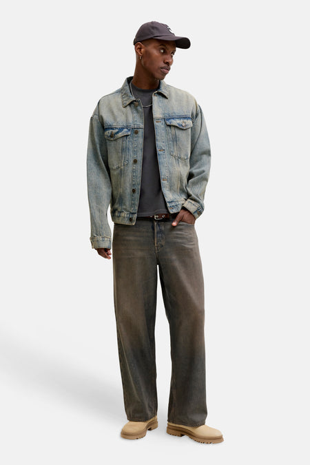 Zwart korte mouwen T-shirt van CORE BY JACK & JONES, gedragen onder een lichtblauwe denim jas, gecombineerd met donkere jeans en beige schoenen, full body lifestyle view.