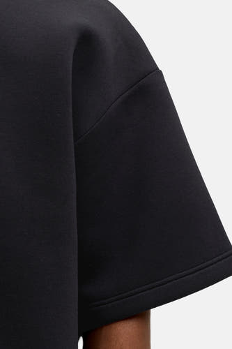 Zwarte ronde hals sweater van CORE BY JACK & JONES, close-up van mouw met gladde stof en nette naden