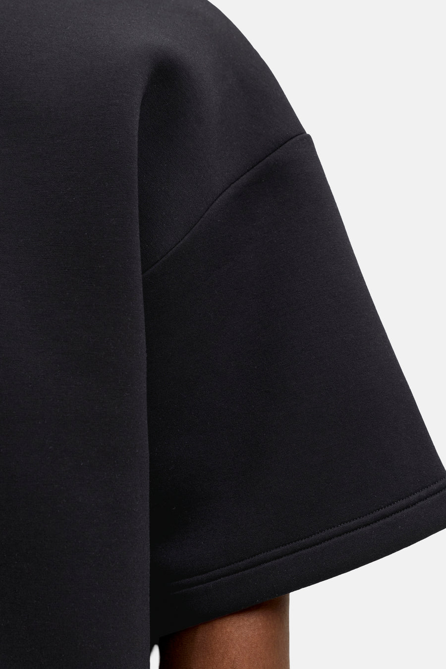 Zwarte ronde hals sweater van CORE BY JACK & JONES, close-up van mouw met gladde stof en nette naden