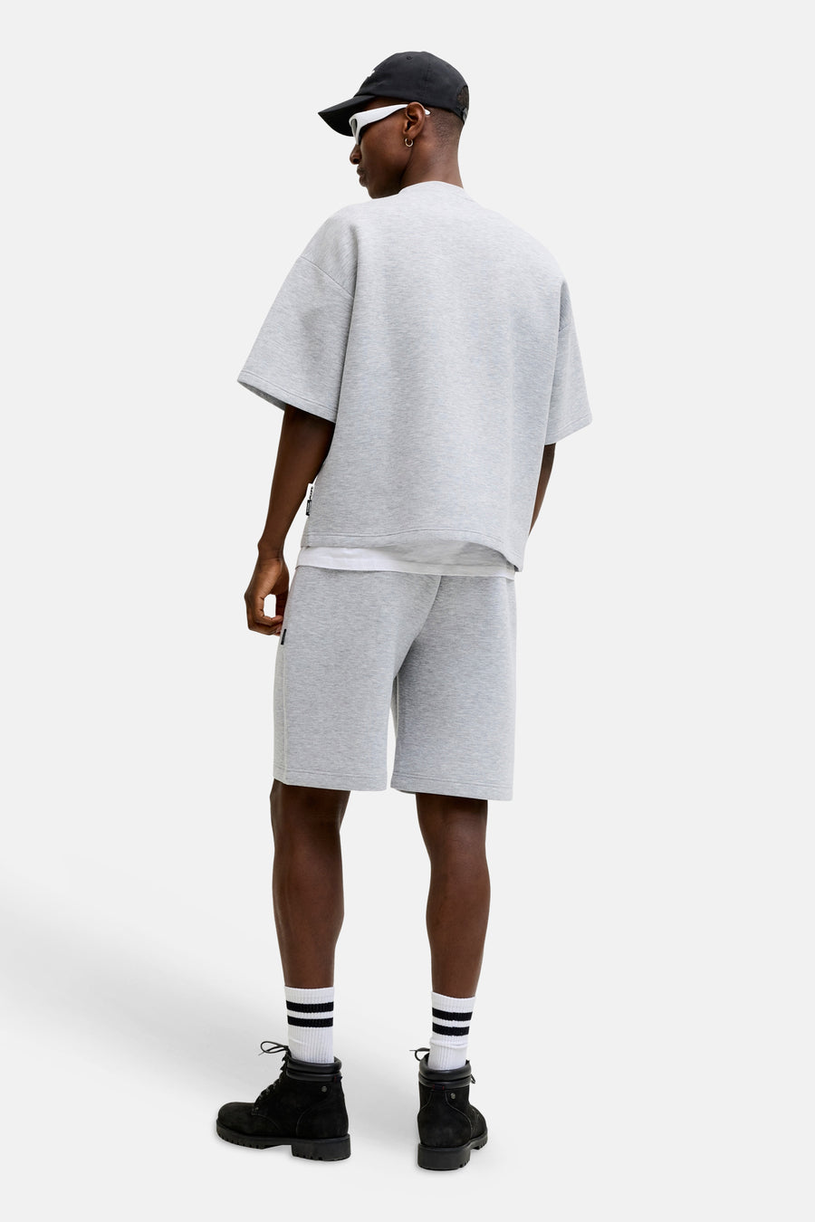 Grijze ronde hals sweater van CORE BY JACK & JONES, achterzijde, oversized fit, gecombineerd met grijze shorts en zwarte laarzen