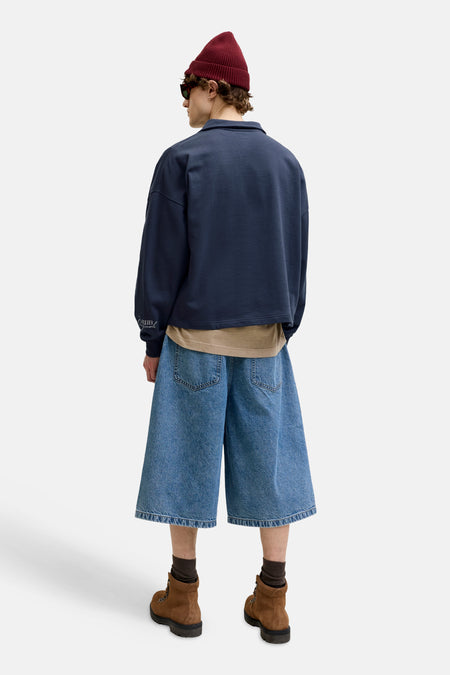 Pull court bleu marine à col rond de ORIGINALS BY JACK & JONES, avec texte blanc 'ATELIER originals' sur la manche, photographié de dos.
