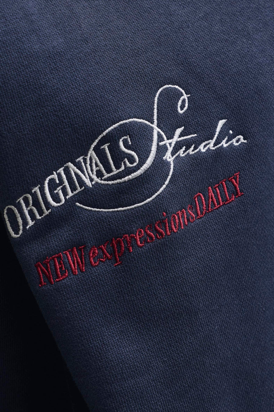 Donkerblauwe sweater met ronde hals van ORIGINALS BY JACK & JONES, met witte en rode geborduurde tekst.