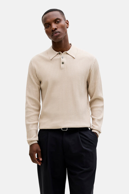 Beige trui met ronde hals van PREMIUM by JACK & JONES, met geribbelde textuur en lange mouwen, gedragen door een man met een zwarte broek.