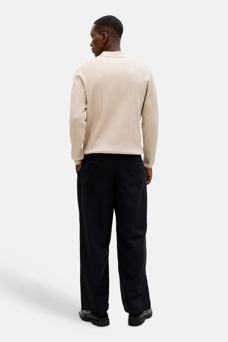Pull beige côtelé avec col de PREMIUM by JACK & JONES, vu de dos avec pantalon noir et chaussures.