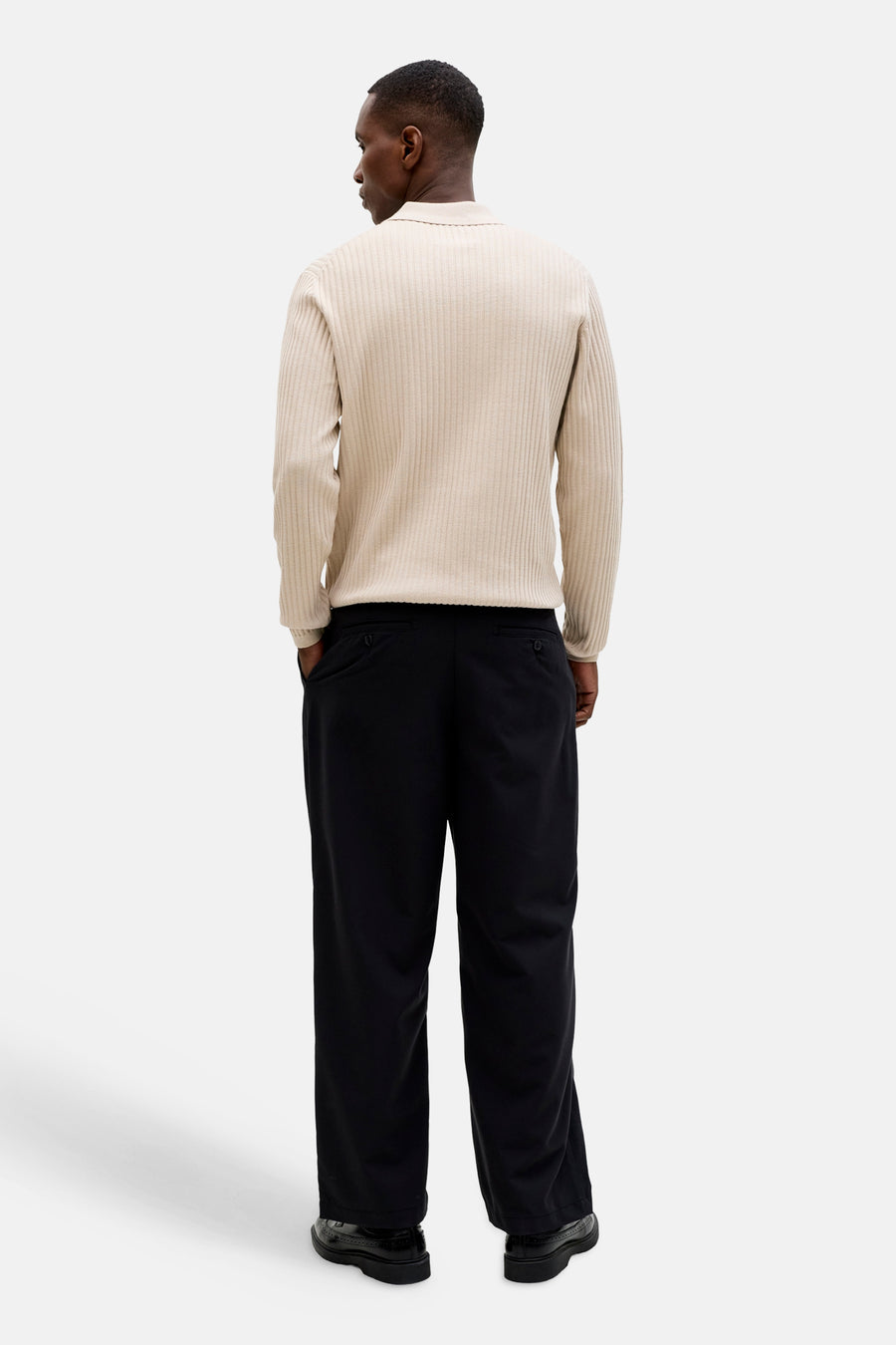 Beige geribbelde trui met kraag van PREMIUM by JACK & JONES, van achteren gezien met zwarte broek en schoenen.