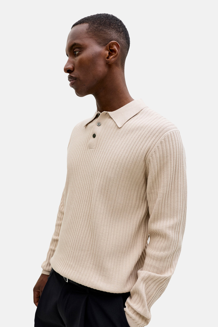 Beige geribbelde trui met polokraag en twee knopen van PREMIUM by JACK & JONES, gedragen door een man in zijaanzicht.