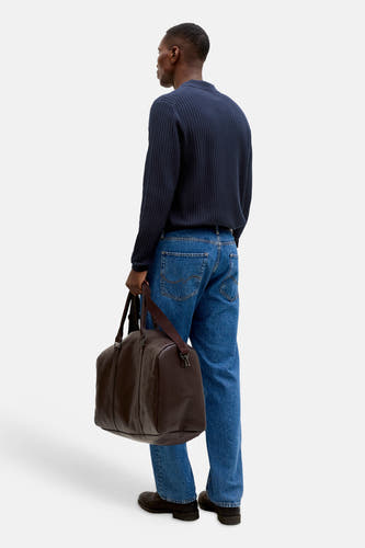 Pull côtelé bleu marine à col polo de PREMIUM by JACK & JONES, porté par un homme avec un jean et un sac week-end marron.