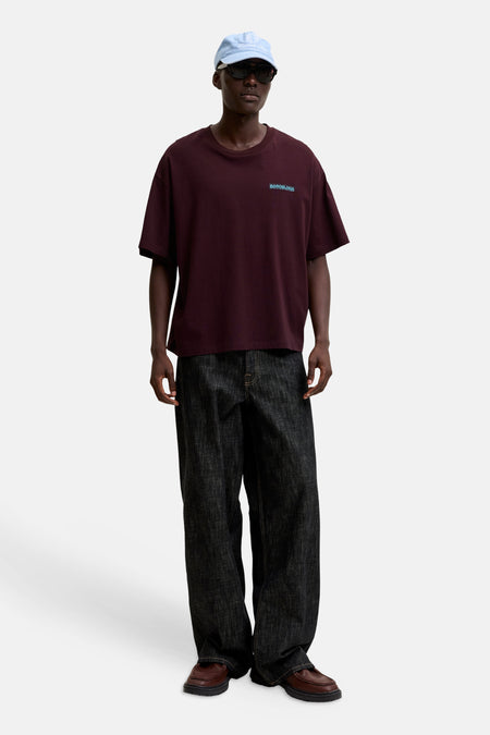 Paarse korte mouwen t-shirt van ORIGINALS BY JACK & JONES, met klein logo op borst, gedragen in lifestyle look met donkere jeans en bruine schoenen