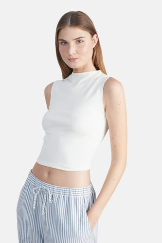 Mouloze top écru de 24 couleurs, porté avec un pantalon rayé à cordon.