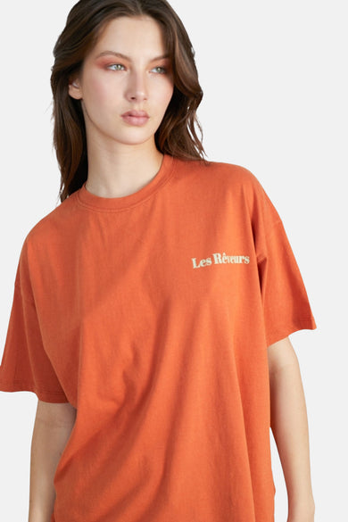 Oranje T-shirt met korte mouwen van 24 colours, met een opschrift in kleine letters op de borst.