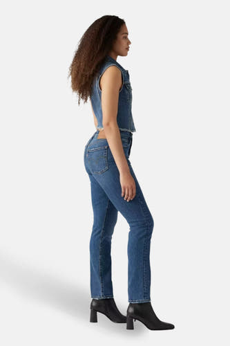 Jeans straight mid blue denim van Levi's, met zwarte enkellaarsjes in zij aanzicht.
