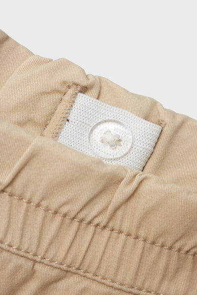 Pantalon beige de LMTD, avec une ceinture ajustable et un nœud visible.