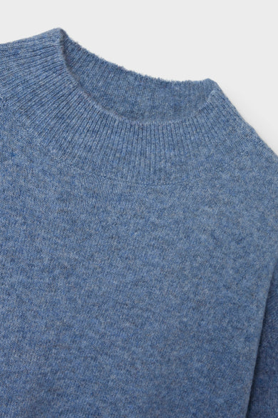Blauwe trui met ronde hals van LMTD, close-up van textuur en de geribbelde halslijn.
