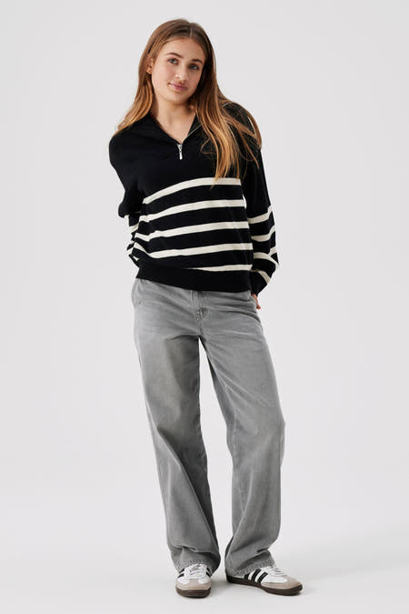 Zwart-wit gestreepte trui van LMTD, met een rits en gecombineerd met grijze jeans en sneakers.
