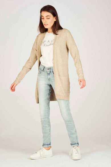 Beige vest van VILA met lange mouwen, gecombineerd met een wit t-shirt en lichte jeans.
