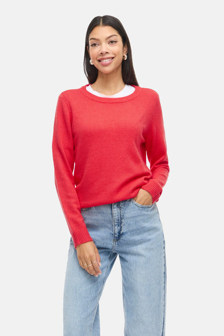 Rode trui met ronde hals van VILA, gedragen met een wit T-shirt en wijde jeans.