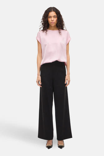 Roze T-shirt met korte mouwen van VILA®, gedragen met wijde zwarte broek en zwarte hakken.
