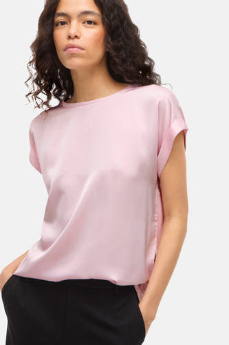 T-shirt rose à manches courtes de VILA®, porté avec un pantalon noir et une coupe décontractée.