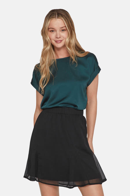 Groene T-shirt van VILA®, met korte mouwen en een zwarte rok.
