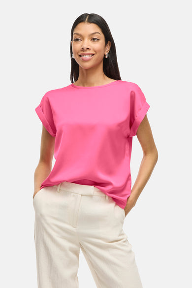 T-shirt rose à manches courtes de VILA®, porté avec un pantalon beige et des boucles d'oreilles argentées.