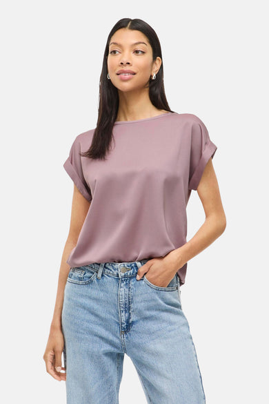 T-shirt rose à manches courtes de VILA®, porté avec des jeans et des sandales argentées.