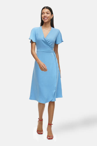 Blauwe jurk met korte mouwen van VILA®, met een wikkelmodel en rode sandalen.
