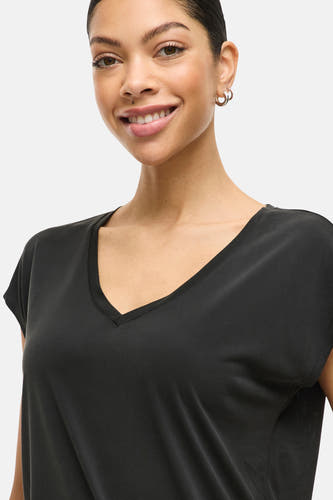T-shirt noir à manches courtes de VILA, avec un col en V et porté avec des boucles d'oreilles dorées.