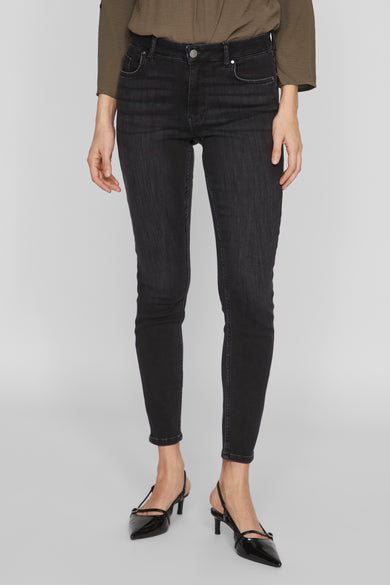 Zwarte skinny jeans van VILA, met subtiele wassing en gedragen met zwarte slingbacks.
