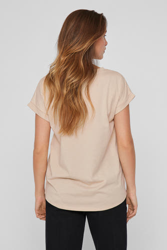 T-shirt beige à manches courtes de VILA, vu par derrière, avec des manches retroussées et un pantalon noir.