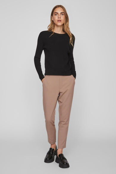 Zwarte trui met ronde hals van VILA®, gecombineerd met beige pantalon en zwarte loafers.

