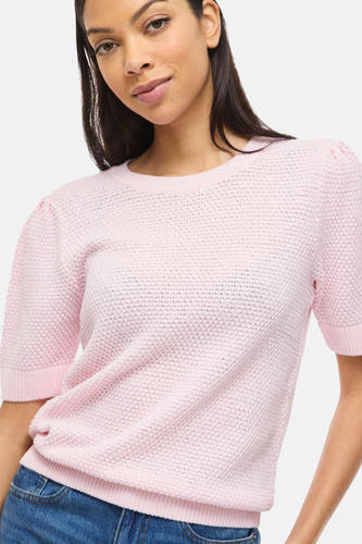 Pull rose de VILA®, à manches courtes et en maille fine, combiné avec un pantalon en jean.