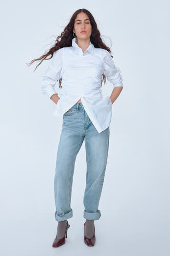 Jean décontracté en denim bleu clair de VILA®, porté avec un chemisier blanc et des escarpins marrons.