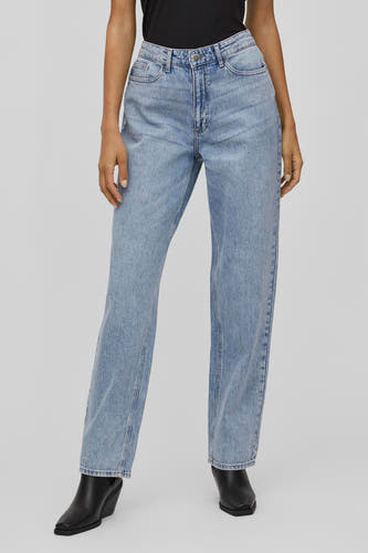 Jean décontracté de denim bleu clair de VILA, avec une coupe droite et associé à des bottes noires.